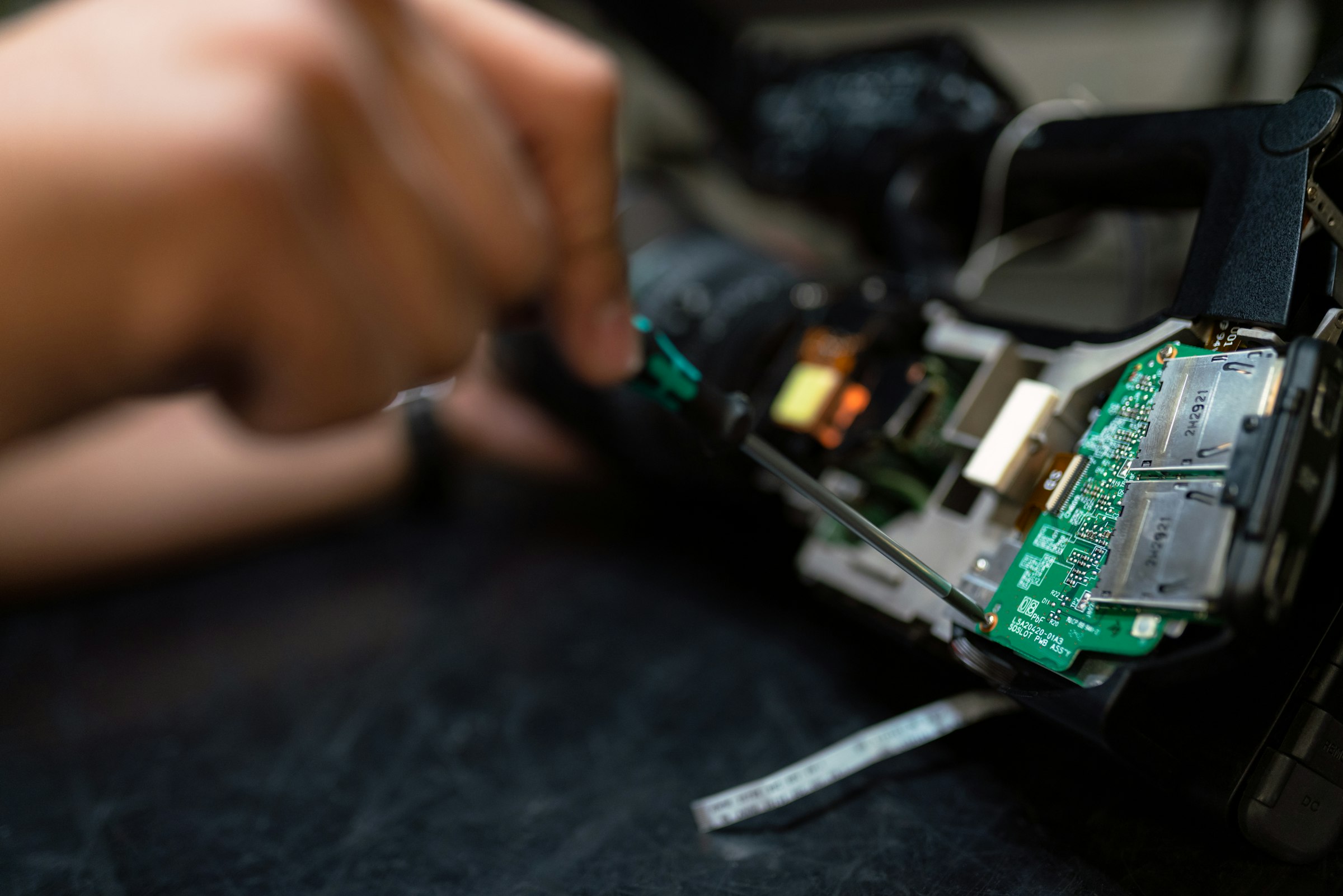 Manos ajustando un circuito en un equipo electrónico