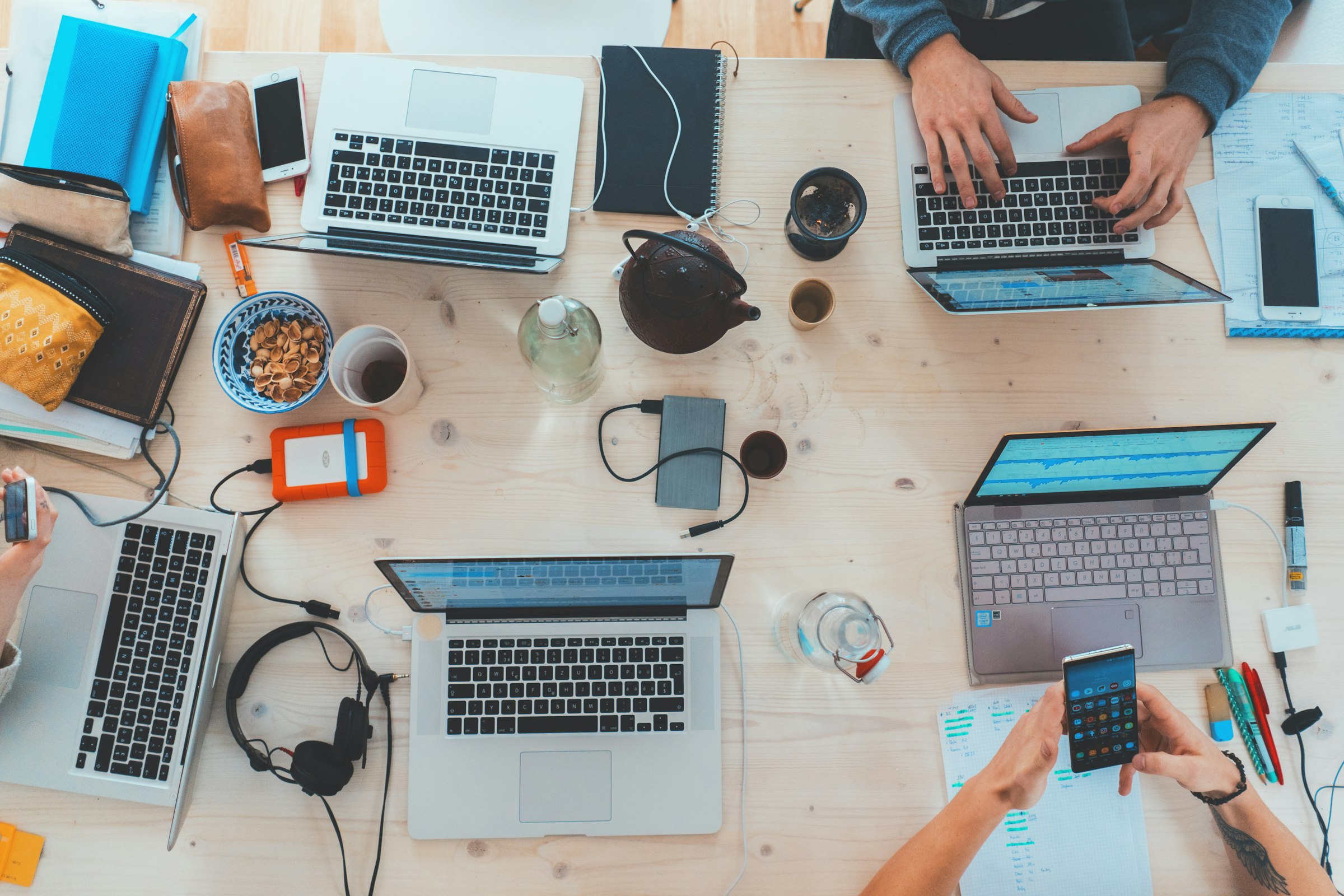 Un equipo trabajando con portátiles sobre la misma mesa
