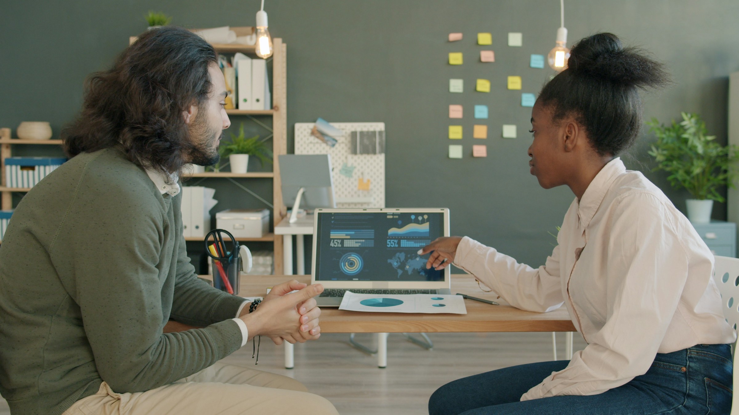 Two people reviewing data on a laptop