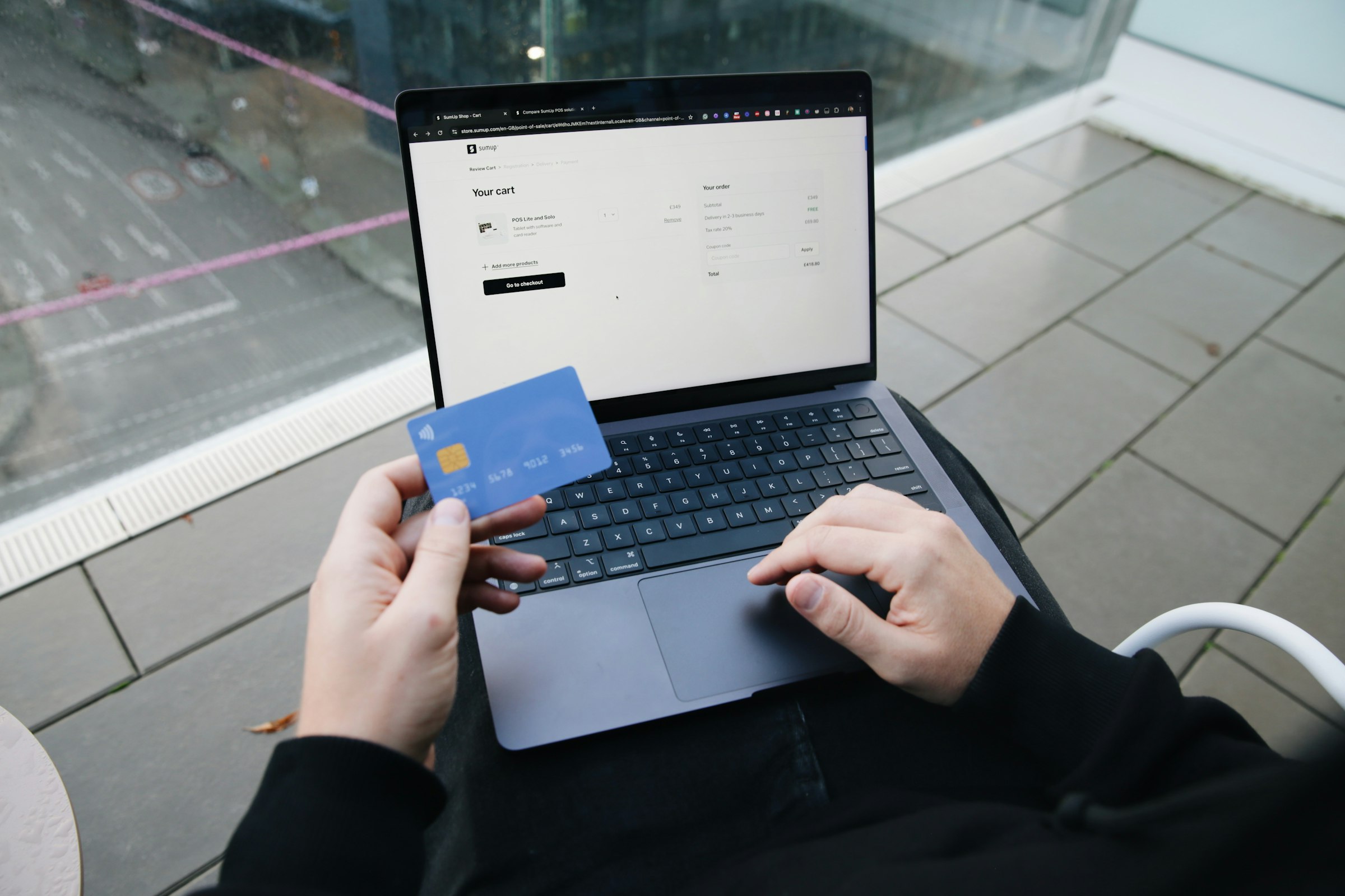 Person with a laptop and card completing an online purchase