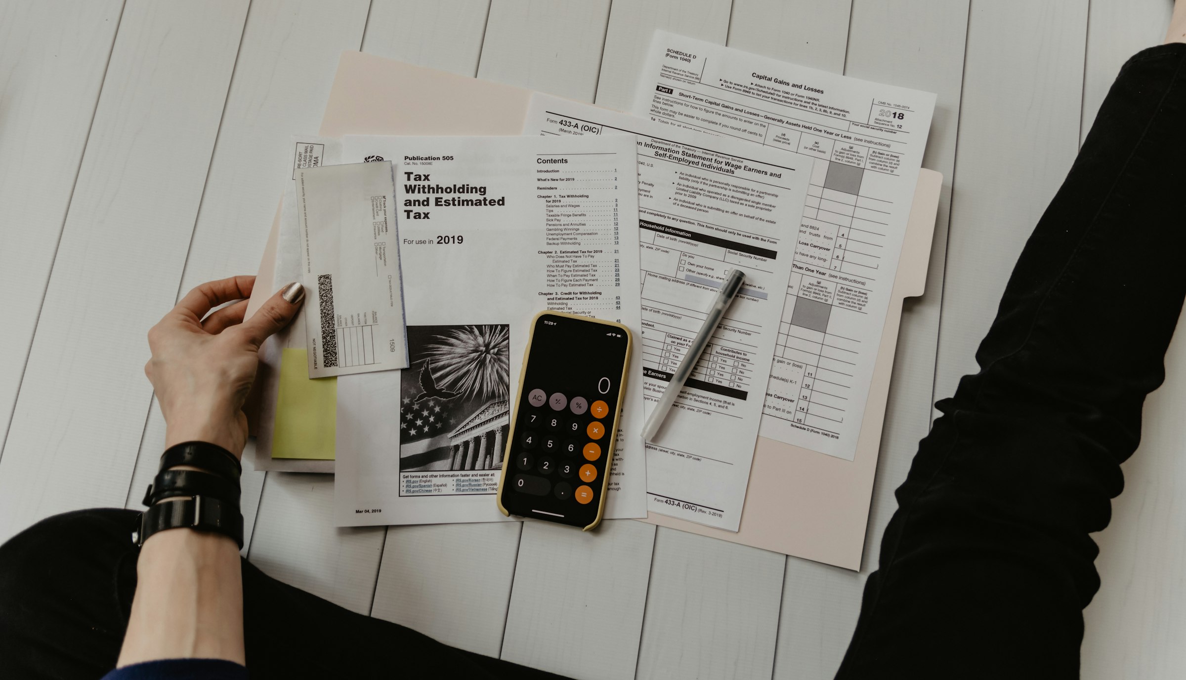 Manos con calculadora y documentos de trabajo financiero